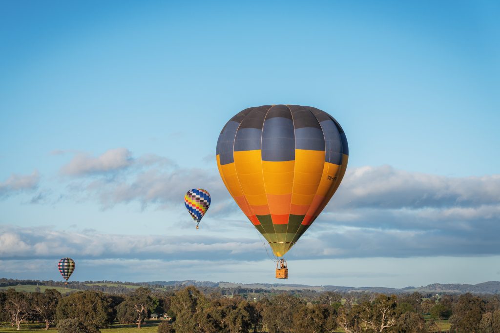 Multiple ballooning flying above fields